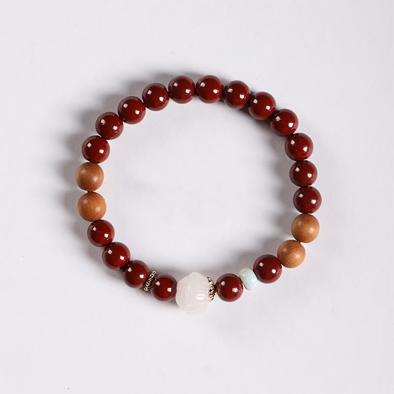 Cinnabar Wood Lotus Fu Bracelet - overhead white bg, white lotus bead with gold spacers, zen