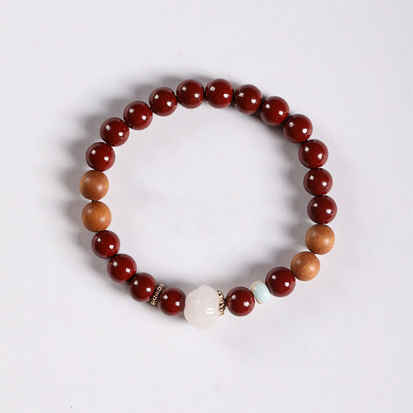 Cinnabar Wood Lotus Fu Bracelet - overhead white bg, white lotus bead with gold spacers, zen