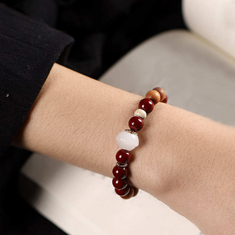 Cinnabar Wood Lotus Fu Bracelet - on wrist side view, red and white bead contrast, elegant