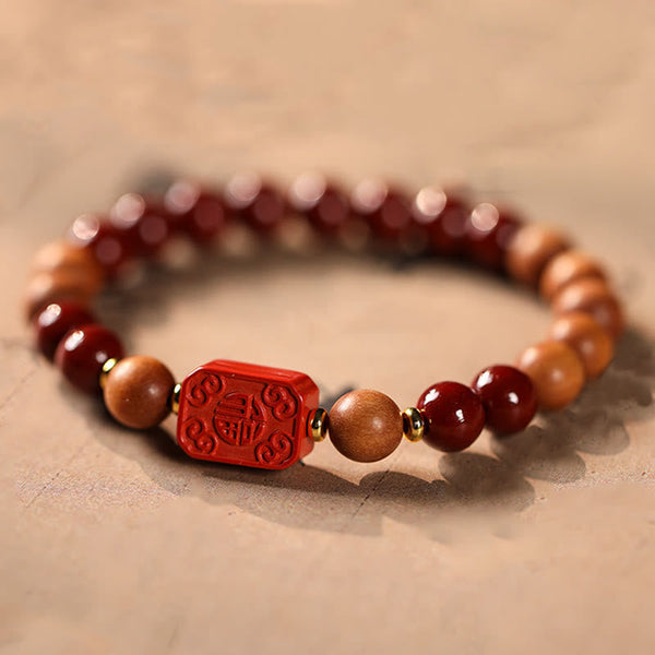 Cinnabar Wood Lotus Fu Bracelet - carved Fu blessing bead close-up, gold spacers, lucky