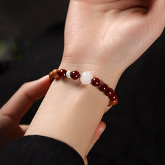 Cinnabar Wood Lotus Fu Bracelet - worn on wrist, lotus centerpiece, hand adjusting, blessing
