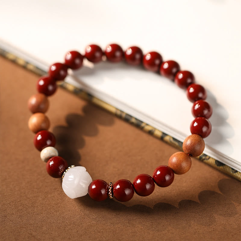 Cinnabar Wood Lotus Fu Bracelet - on book prop, lotus carving detail, warm artisan feel, cultural