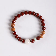 Cinnabar Wood Lotus Fu Bracelet - overhead white bg, white lotus bead with gold spacers, zen