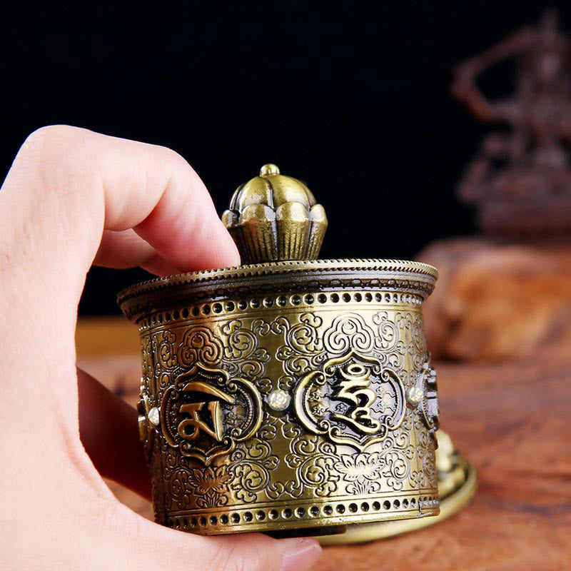 Lotus Prayer Wheel - Fingers on lotus finial ready to spin, antique brass Buddhist ritual tool