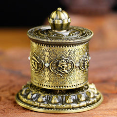 Lotus Prayer Wheel - Ornate brass mani wheel with lotus finial on wood, spiritual peace decor