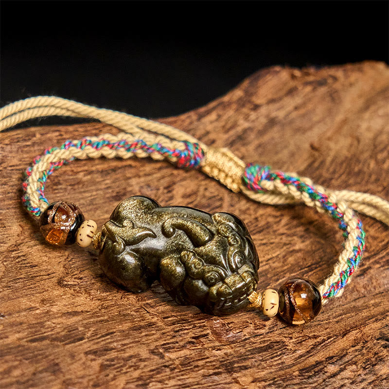 Gold Sheen Obsidian PiXiu bracelet – rope bracelet on wood side angle detail, obsidian wealth charm