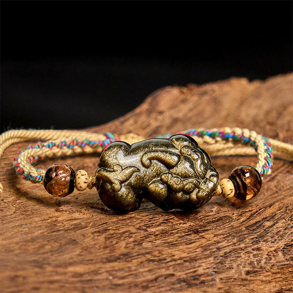 Gold Sheen Obsidian PiXiu bracelet – rope bracelet on wooden surface front view, protection good luck