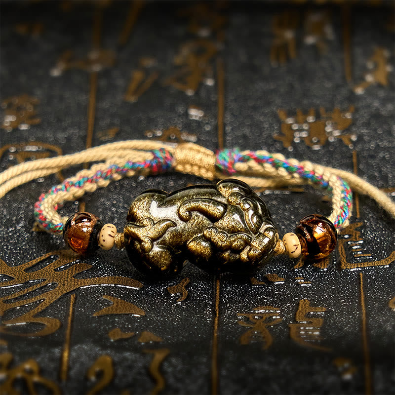 Gold Sheen Obsidian PiXiu bracelet – beige rope with colored threads on black background, feng shui wealth