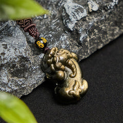 Gold Sheen Obsidian PiXiu Wealth Rope Necklace Pendant – pendant on dark rock with green leaf, maroon rope feng shui wealth
