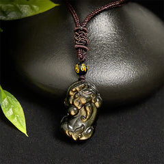 Gold Sheen Obsidian PiXiu Wealth Rope Necklace Pendant – hanging against black stone, green leaf accent, obsidian necklace