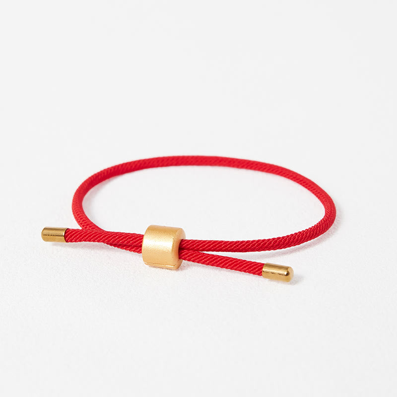 Red woven cord adjustable bracelet with brushed gold cylindrical bead and matching end caps, Chinese lucky string design studio product photo