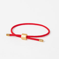 Red woven cord adjustable bracelet with brushed gold cylindrical bead and matching end caps, Chinese lucky string design studio product photo