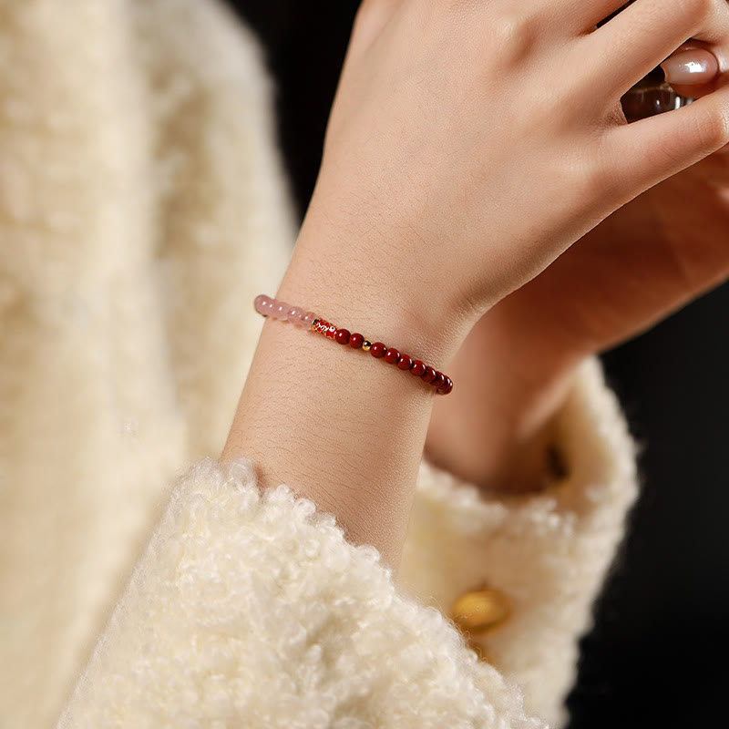 Cinnabar Strawberry Quartz Koi Fish Bracelet – on wrist, cinnabar pink quartz, dark backdrop