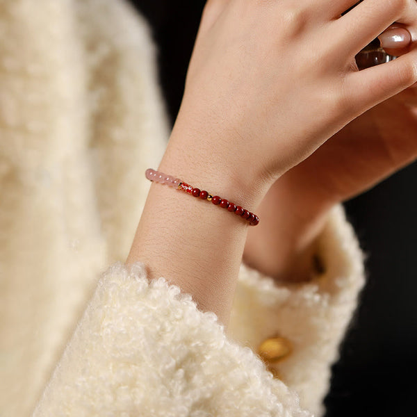 Cinnabar Strawberry Quartz Koi Fish Bracelet – on wrist, cinnabar pink quartz, dark backdrop