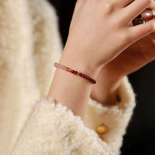 Cinnabar Strawberry Quartz Koi Fish Bracelet – on wrist, cinnabar pink quartz, dark backdrop