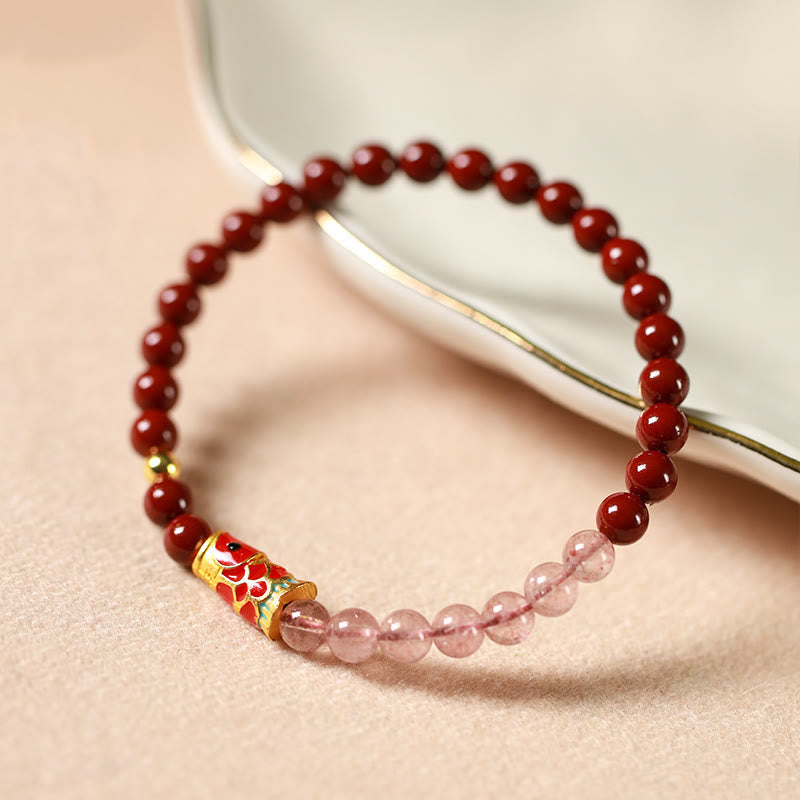 Cinnabar Strawberry Quartz Koi Fish Bracelet – beads on gold-rim ceramic dish, side angle
