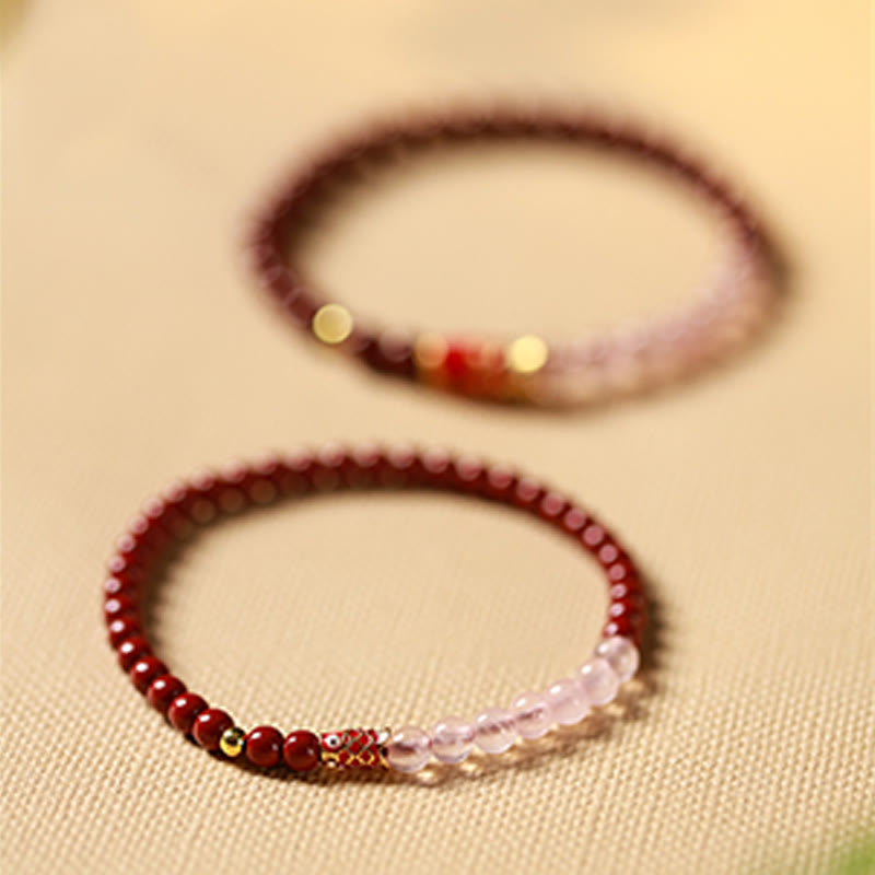 Cinnabar Strawberry Quartz Koi Fish Bracelet – two bracelets on linen, 45 degree, depth of field