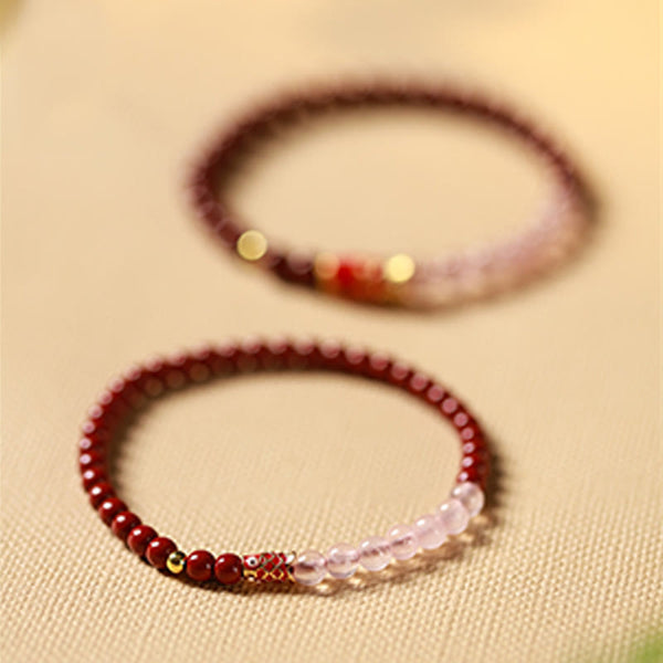 Cinnabar Strawberry Quartz Koi Fish Bracelet – two bracelets on linen, 45 degree, depth of field