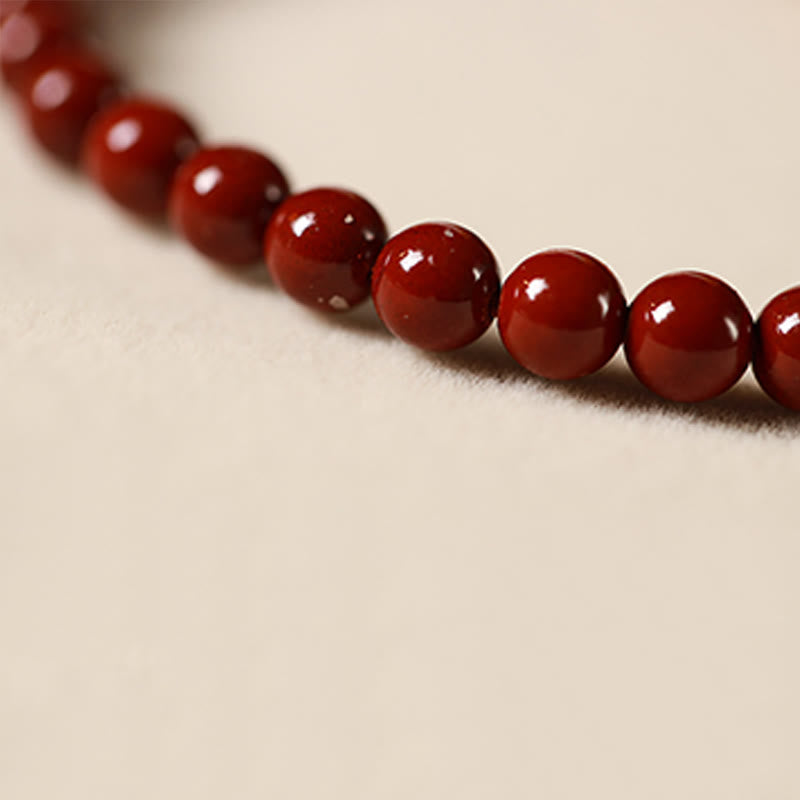 Cinnabar Strawberry Quartz Koi Fish Bracelet – macro close-up glossy cinnabar red beads