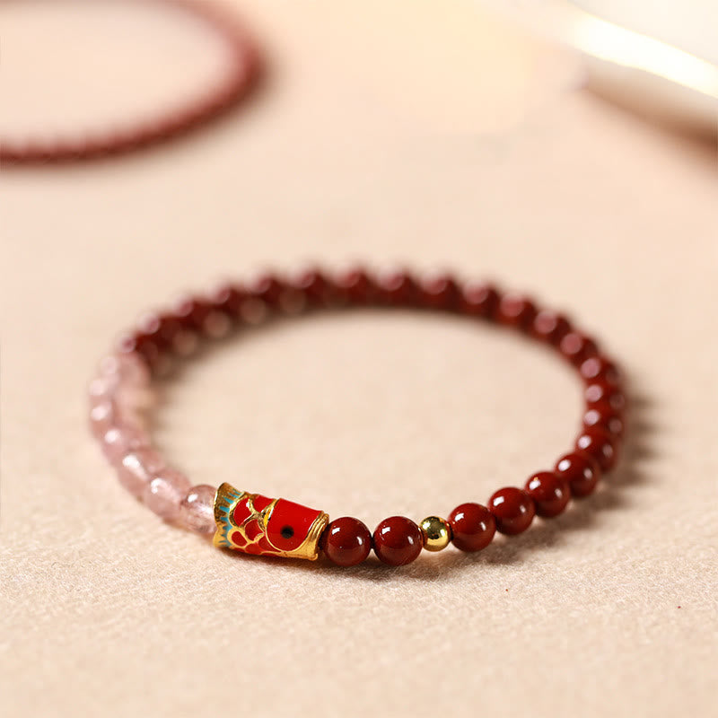 Cinnabar Strawberry Quartz Koi Fish Bracelet – side angle on linen, red pink beads, koi charm