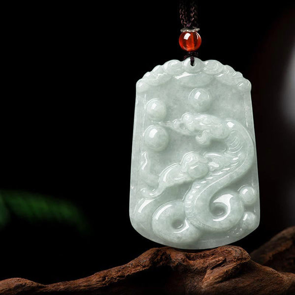 Natural Jade Zodiac Amulet Pendant – Qilin dragon-horse jade relief on dark fabric angled view, Noble
