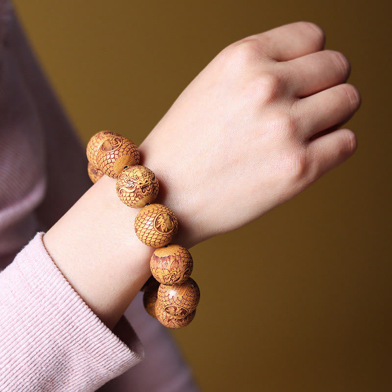 Sandalwood Dragon Bracelet – dragon scale relief beads on wrist warm background, Strength