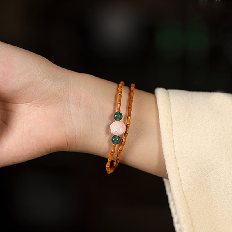 Olive Pit Lotus Double Circle Bracelet – wrist shot with dark background highlighting carved lotus and jade accents, Elegant