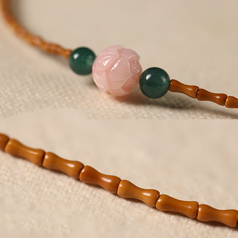 Olive Pit Lotus Double Circle Bracelet – macro of carved pink lotus bead and bamboo-style olive pit chain, Delicate