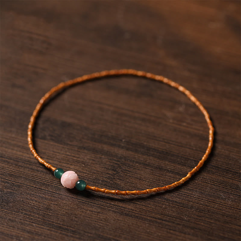 Olive Pit Lotus Double Circle Bracelet – single strand on dark wood with amber olive pit and green jade, Natural