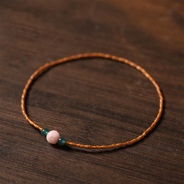 Olive Pit Lotus Double Circle Bracelet – single strand on dark wood with amber olive pit and green jade, Natural