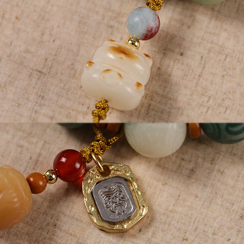 Bodhi Seed Zakiram Bracelet - Macro detail split view of carved animal bead and embossed metal charm, artisan craftsmanship