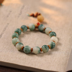 Bodhi Seed Zakiram Bracelet - Arranged on aged parchment with marbled green beads in soft focus, spiritual beaded bracelet