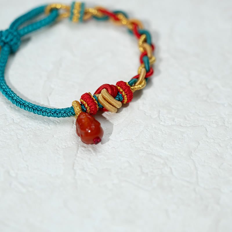 Natural Red Agate PiXiu Braided Bracelet – alternate angle on marble white surface, PiXiu bead charm