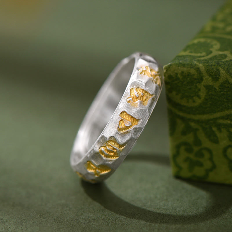 Hammered Om Mani Padme Hum Ring - styled with gold patterned green prop, mantra silver jewelry