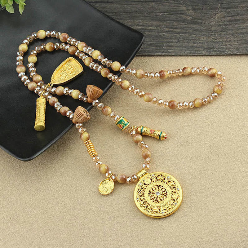 Tiger Eye Mala Necklace – filigree pendant on dark dish with foliage, tiger eye