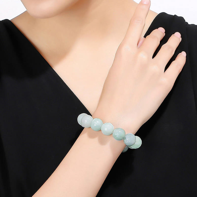 Jade Lotus Bead Bracelet – pale mint green beads worn on wrist, carved jade