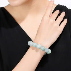 Jade Lotus Bead Bracelet – pale mint green beads worn on wrist, carved jade