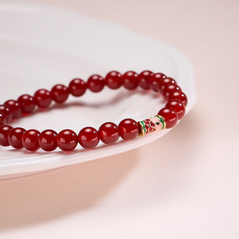 Natural Red Agate Koi Fish Bracelet – red agate bracelet, low side angle on cream ceramic
