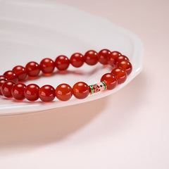 Natural Red Agate Koi Fish Bracelet – red agate on white ceramic dish, side perspective