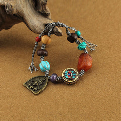 Tibetan Zakiram Turquoise Lotus Rope Bracelet – cord bracelet with turquoise and amber beads draped on driftwood, Boho