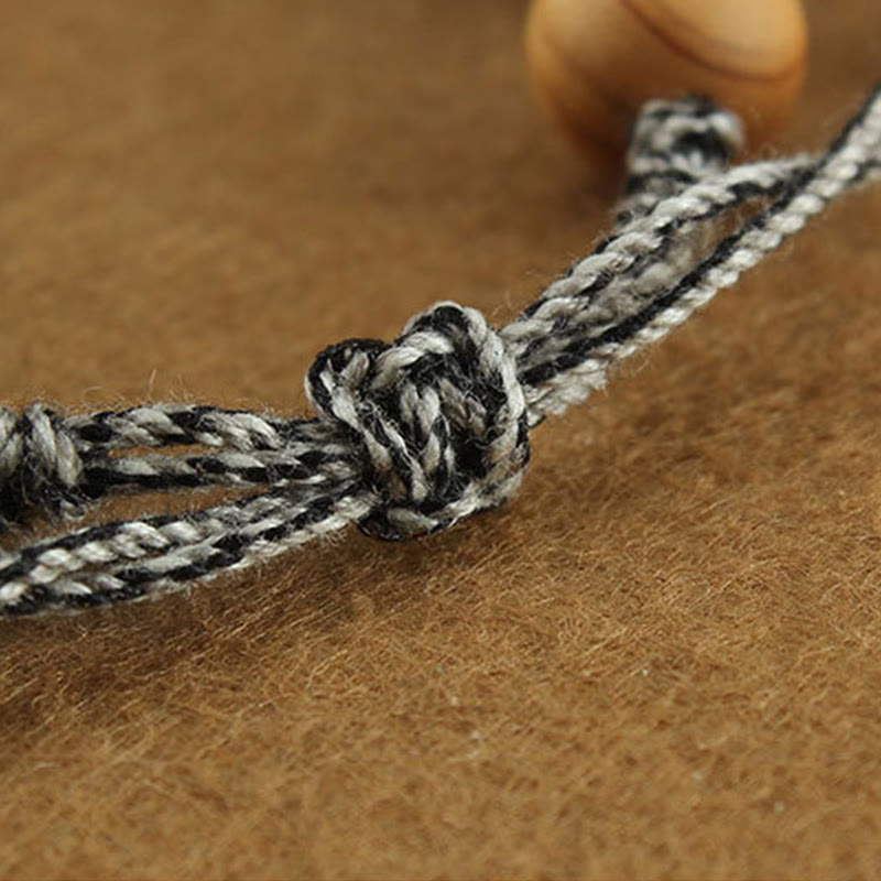 Tibetan Zakiram Turquoise Lotus Rope Bracelet – macro of adjustable sliding knot with wooden bead and cord texture, Wealth