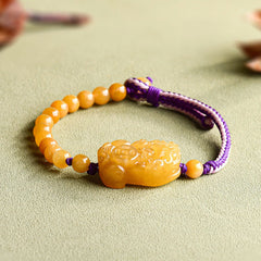Golden Silk Jade PiXiu Wealth Bracelet – flat lay on green fabric front view, feng shui good luck jade