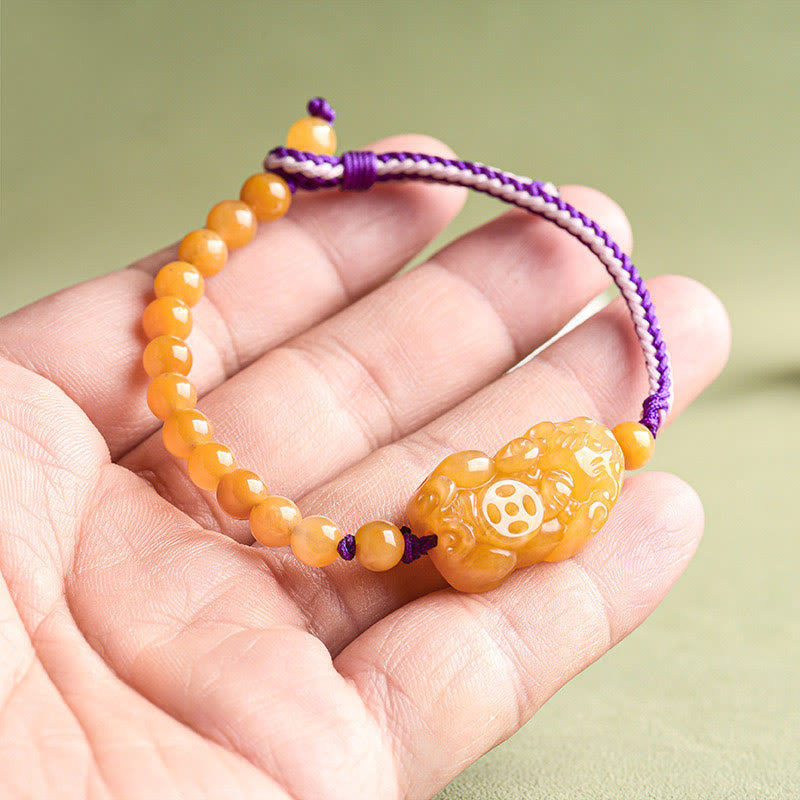 Golden Silk Jade PiXiu Wealth Bracelet – held in palm scale view, natural jade beads texture