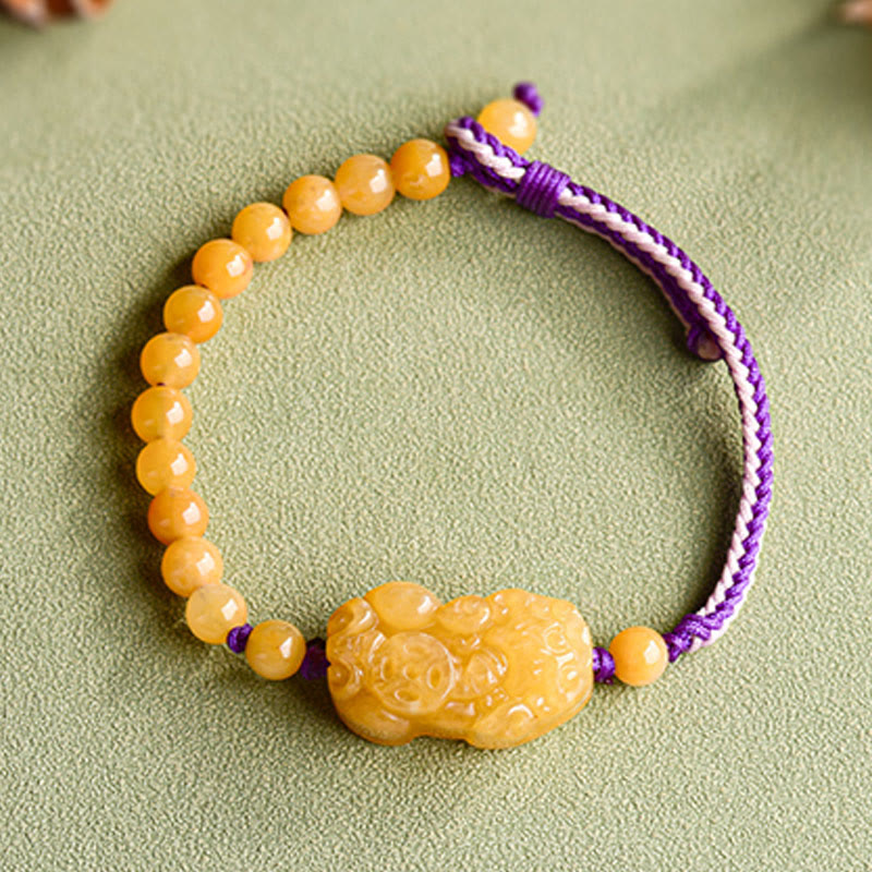 Golden Silk Jade PiXiu Wealth Bracelet – top down view on green background, PiXiu bead bracelet