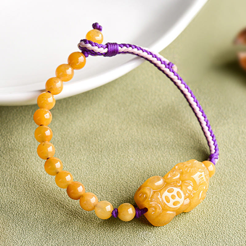 Golden Silk Jade PiXiu Wealth Bracelet – beside white ceramic bowl side angle, adjustable cord bracelet