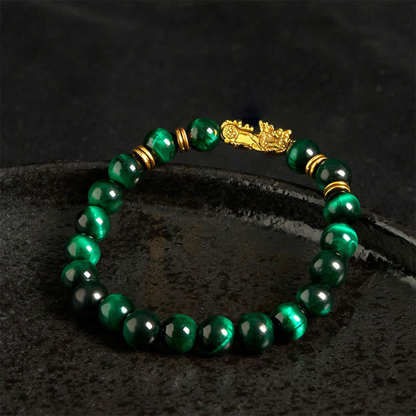 Multi-Color Tiger Eye PiXiu bracelet – green tiger eye beads with gold PiXiu on dark stone, feng shui