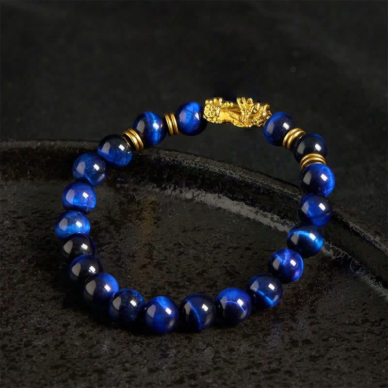 Multi-Color Tiger Eye PiXiu bracelet – blue tiger eye side view on black textured stone, good luck jewelry