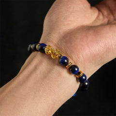 Multi-Color Tiger Eye PiXiu bracelet – gold PiXiu charm on male wrist closeup, wealth courage feng shui