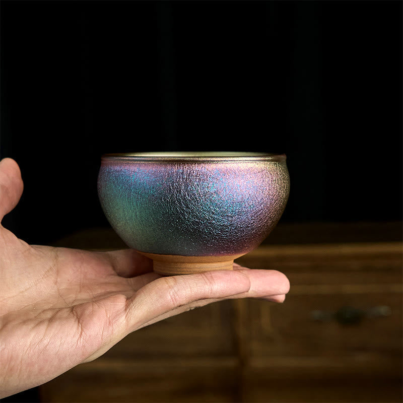Jianzhan Golden Lotus Tea Cup – blue-purple crystalline glaze exterior held in hand, handmade ceramic