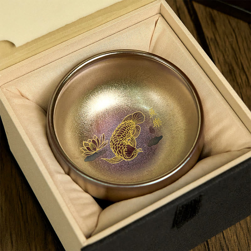 Jianzhan Koi Fish Lotus Teacup – in silk-lined luxury gift box, iridescent bronze-gold, gold koi and lotus, top-down view